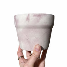 Load image into Gallery viewer, Pot de béton marbré rose et blanc tenue dans une main
